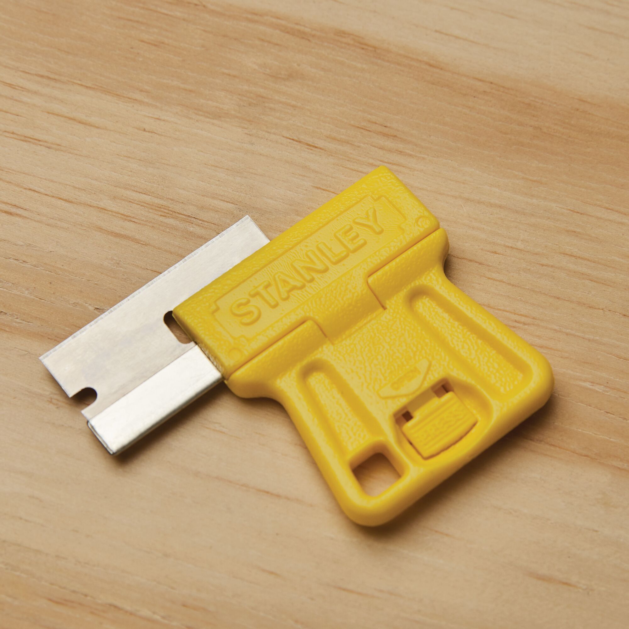Blade reversing feature for safe storage in high visibility mini razor blade scraper.