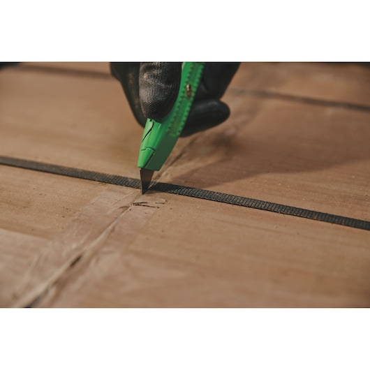 Overhead view of 5 and 7 eighths inch High visibility retractable utility knife opening cardboard box.