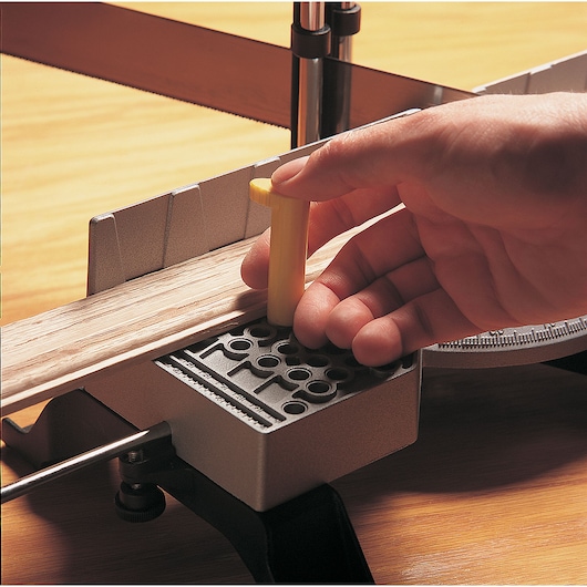 Adjustable angle clamping miter box with 22 inch saw in use.