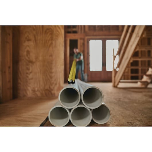 25 foot FATMAX classic tape measure being used by a person to measure pipe length.