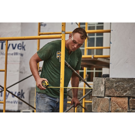 25 foot FATMAX classic tape measure being used by a person to measure distance.