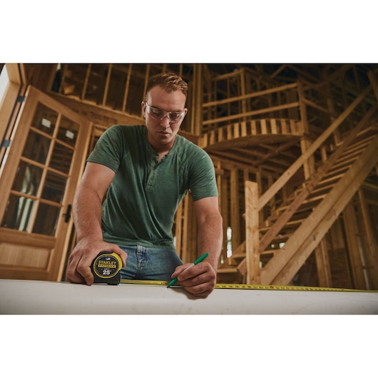 25 foot FATMAX classic tape measure being used by a person in a construction site.