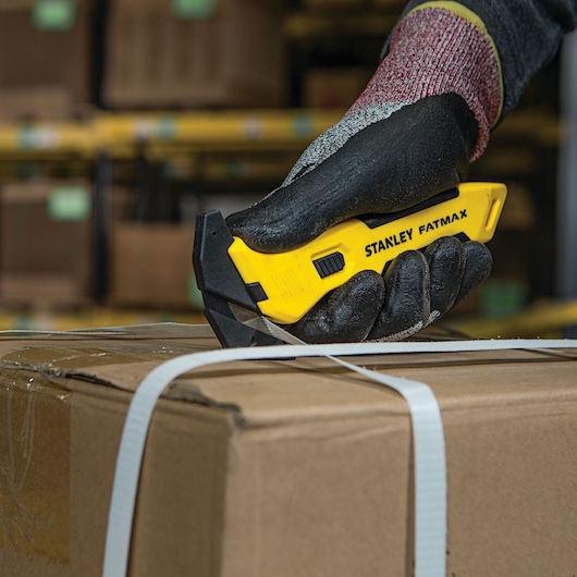 Fatmax single sided replaceable head pull cutter being used to cut straps around a box.