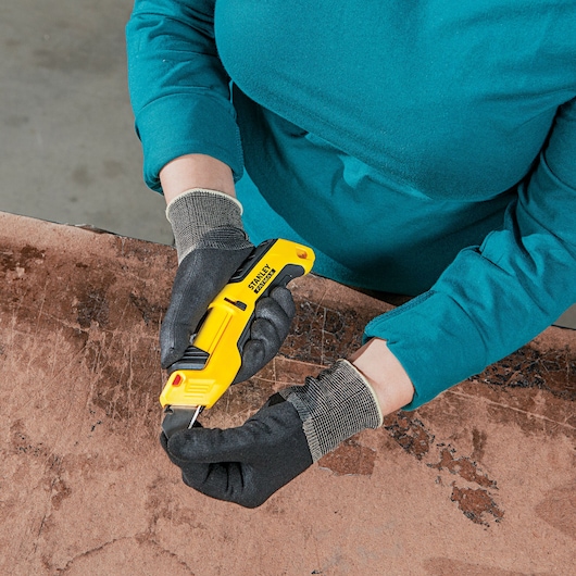 Fatmax auto retract tri slide safety knife being set for use.