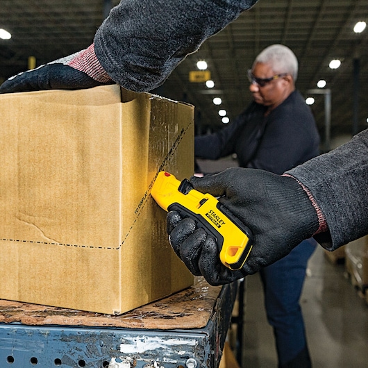 Fatmax auto retract tri slide safety knife being used to cut a box.