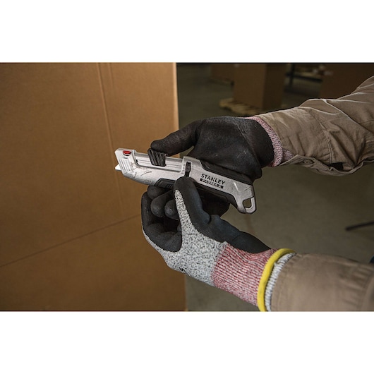 Fatmax premium auto retract tri slide safety knife with a movable cutter switch.