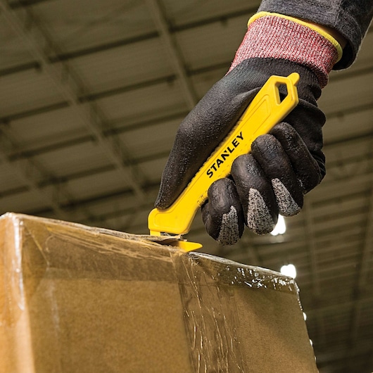 Single Sided Pull Cutter Hook piercer being used for cutting cello tape on cardboard box.