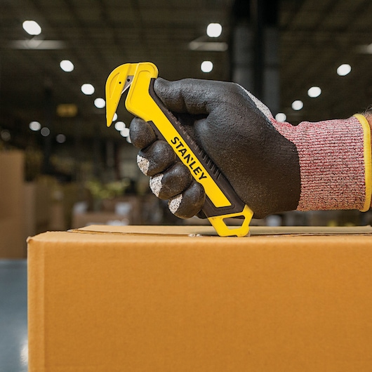 SINGLE SIDED BI MATERIAL PULL CUTTER being used for opening box.