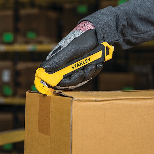 SINGLE SIDED BI MATERIAL PULL CUTTER being used for opening box from rounded side.