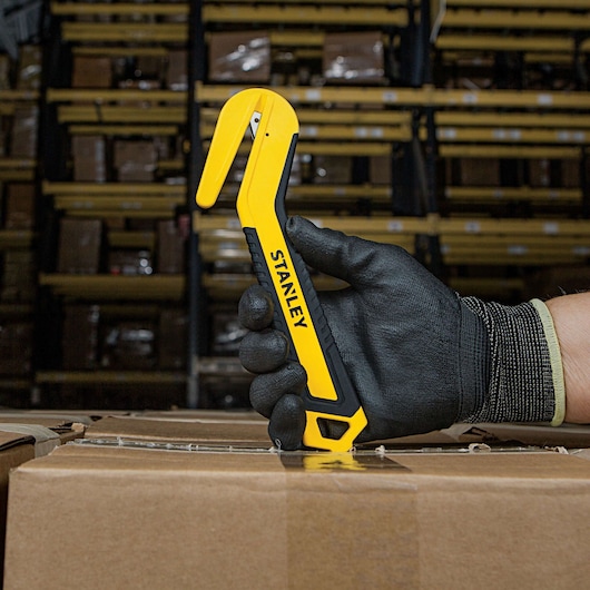 SINGLE SIDED ROUND TIP BI MATERIAL PULL CUTTER BEING USED FOR OPENING BOXES.