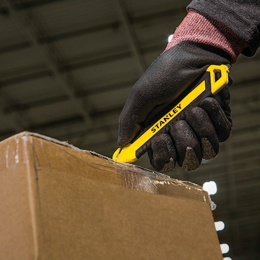 DOUBLE SIDED BI MATERIAL PULL CUTTER being used for opening package.