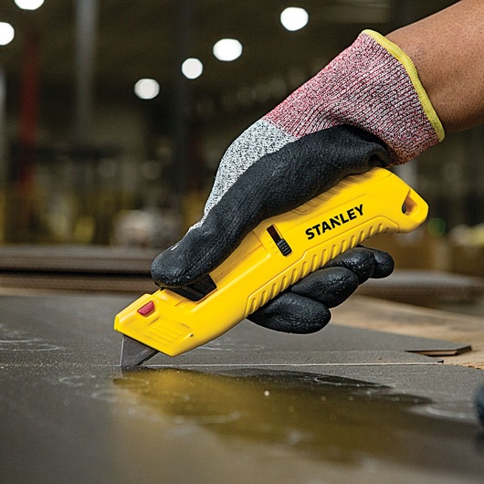 Tri Slide Safety Knife being used for cutting.