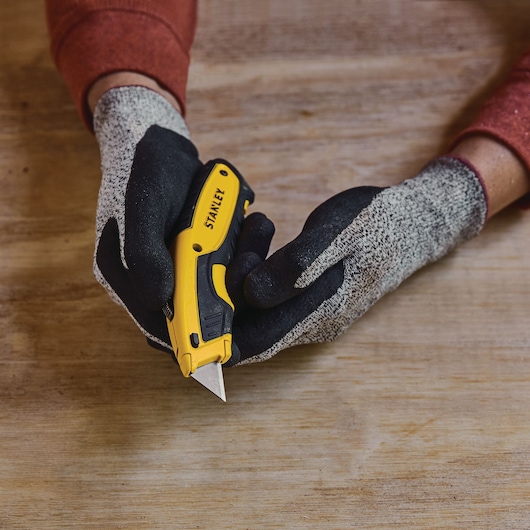 Retractable Utility Knife being held by person.