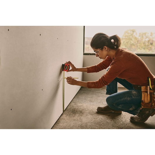 25 FOOT HIGH VISIBILITY LEVER LOCK TAPE MEASURE in use by person.