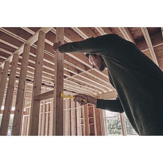 11 inch Double End Nail Puller being used by person to pull nail out of wood.