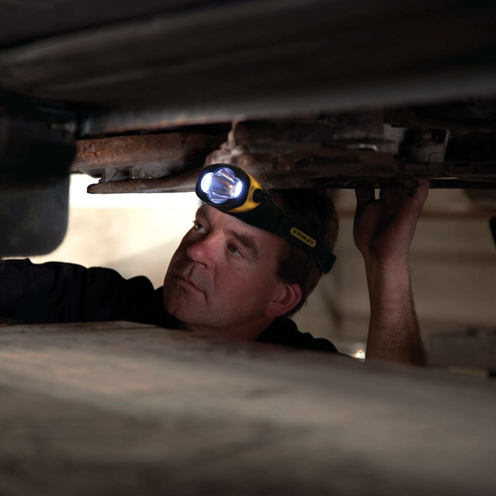 Waterproof L E D head lamp being used by a person to work in the dark.