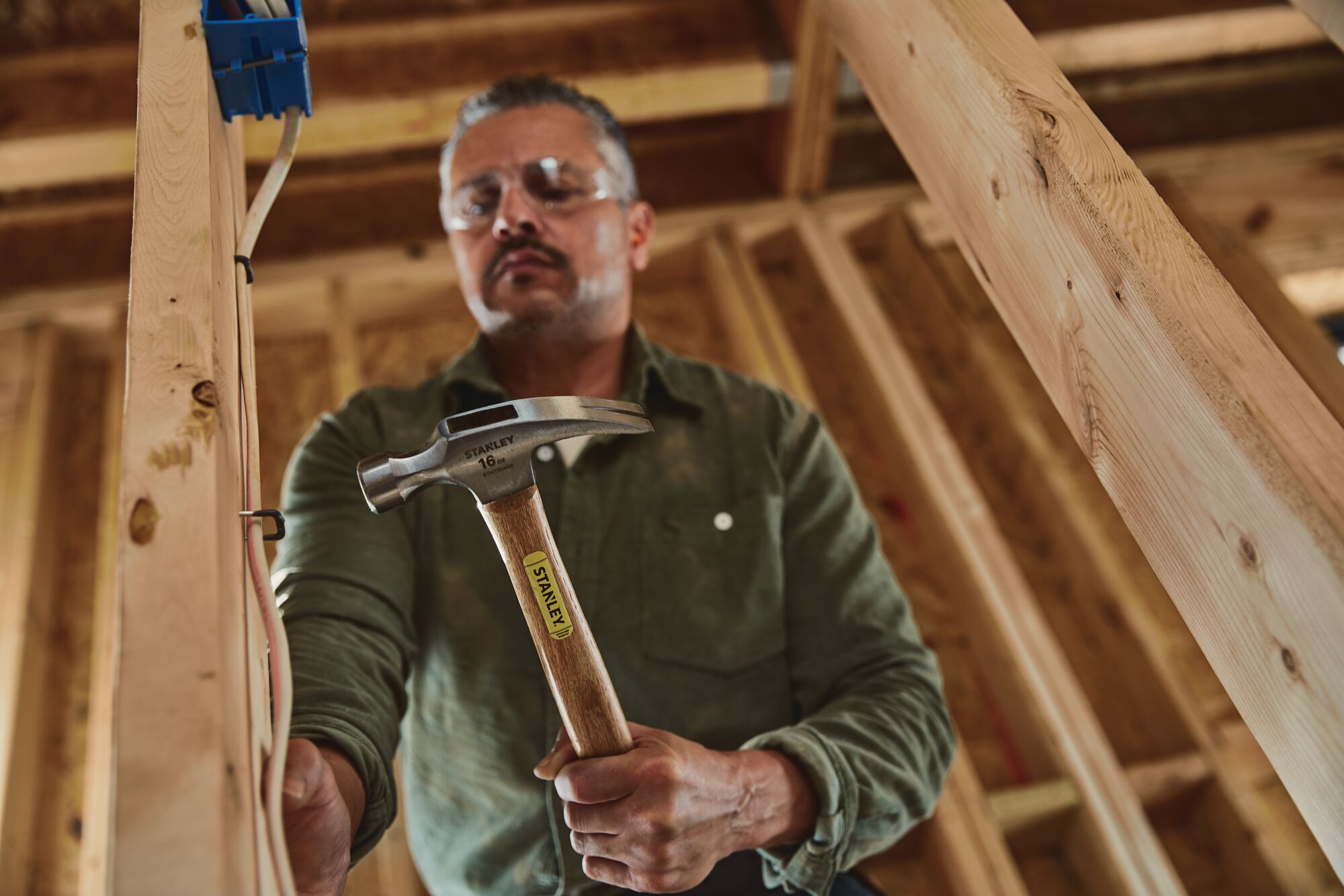 16 OUNCE RIP CLAW WOOD HANDLE HAMMER in use by person.